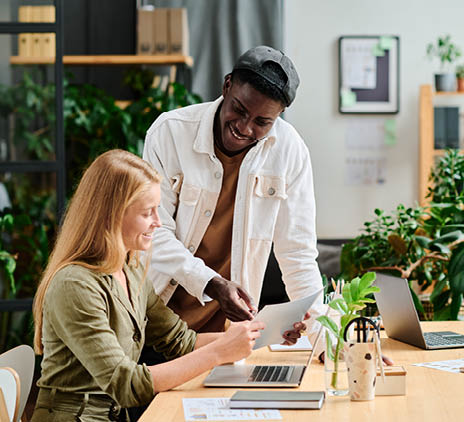 smiling man and women looking at paper in office. 